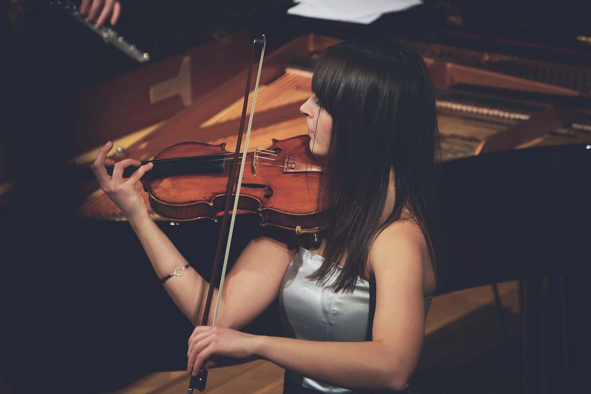 musical instrument woman playing violin beside grand piano violin